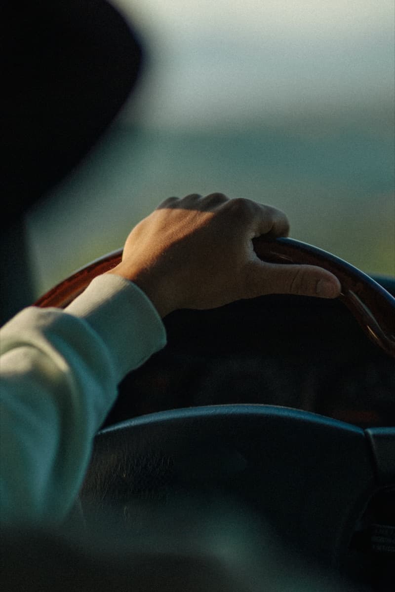 A driver resting a hand on the steering wheel